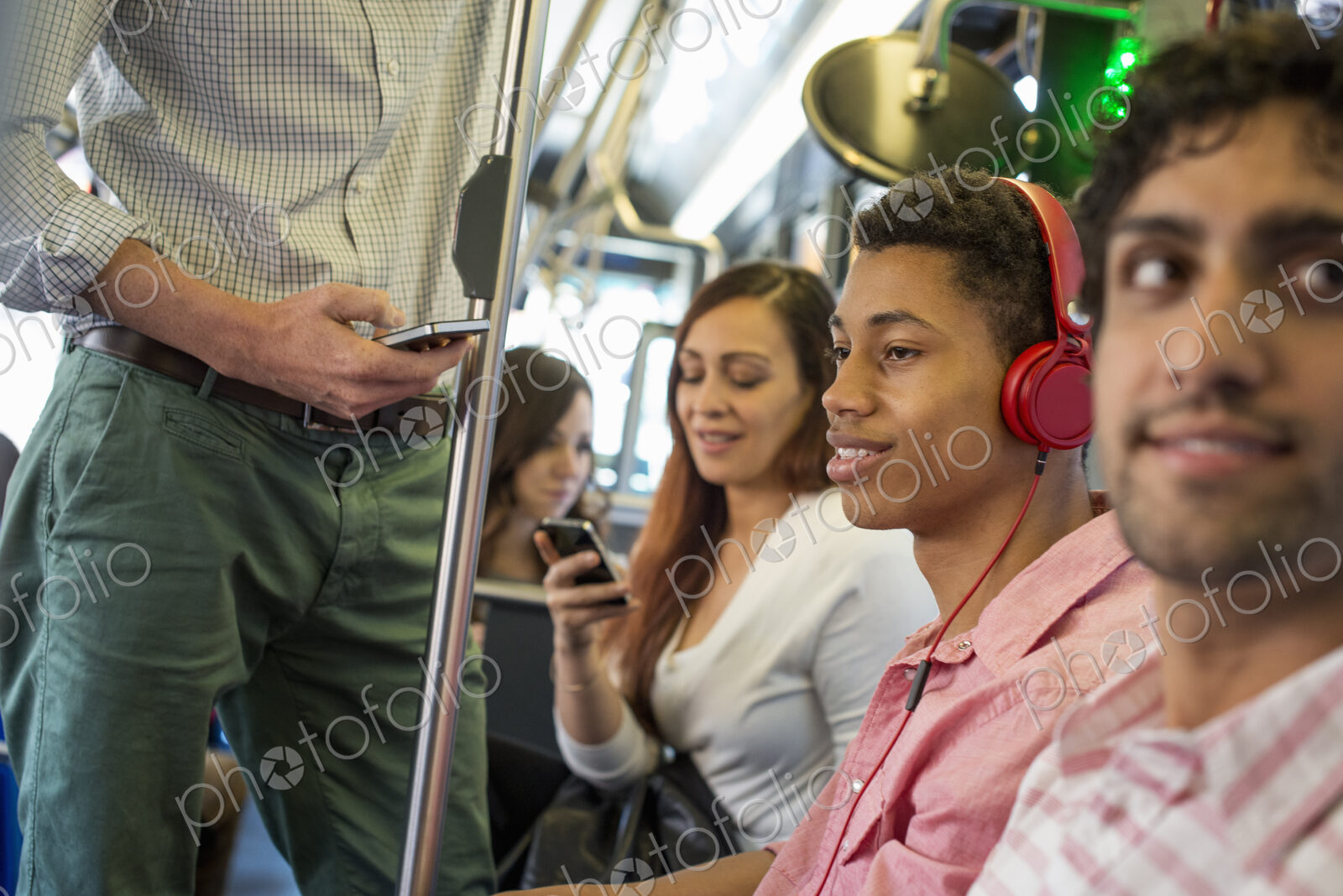 Urban Lifestyle. A group of people, men and women on a city bus, in New York city. A…