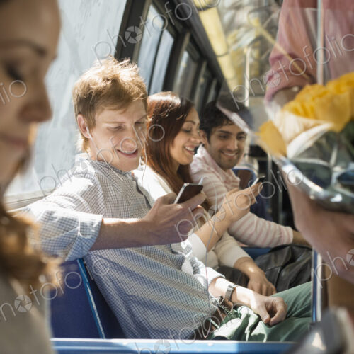 Urban Lifestyle. A group of people, men and women on a city bus, in New York city. Two… Urban Lifestyle. A group of people, men and women on a city bus, in New York city. Two…