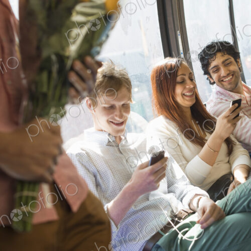 Urban Lifestyle. A group of people, men and women on a city bus, in New York city. Two… Urban Lifestyle. A group of people, men and women on a city bus, in New York city. Two…