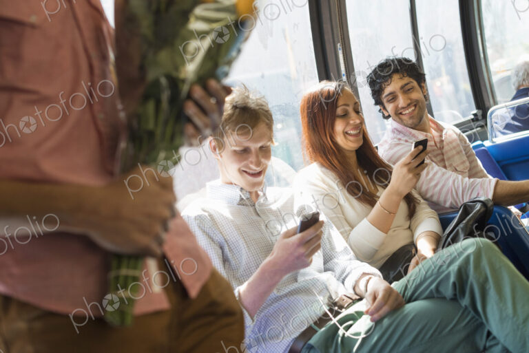 Urban Lifestyle. A group of people, men and women on a city bus, in New York city. Two…