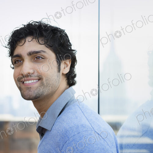 Urban Lifestyle. A young man with black curly hair wearing a blue shirt in the lobby… Urban Lifestyle. A young man with black curly hair wearing a blue shirt in the lobby…