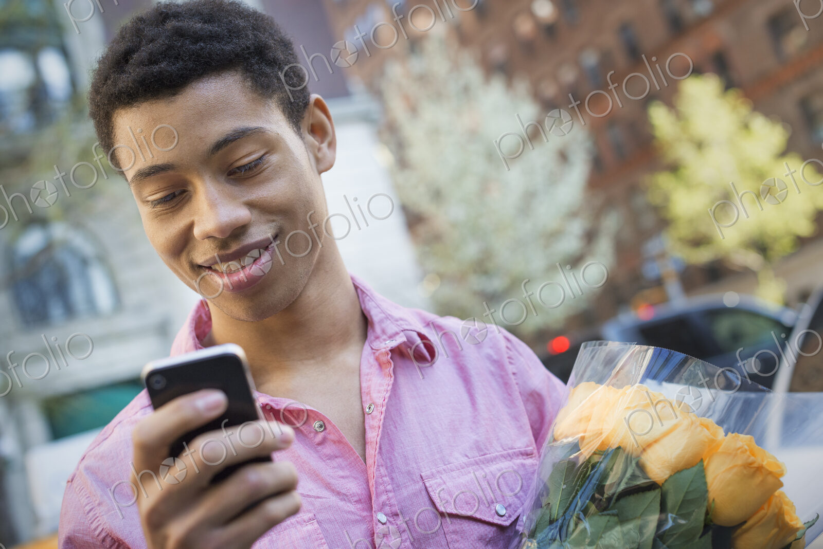 Urban Lifestyle. A young man with short black hair, wearing a pink casual shirt.…