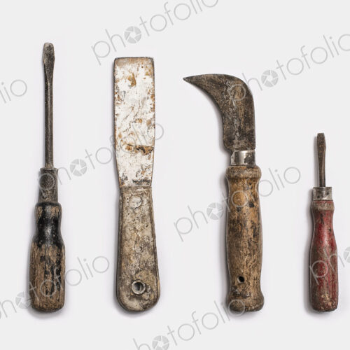 Used tools arranged in a row. Well used, worn handles, shaped wooden smooth texture.…