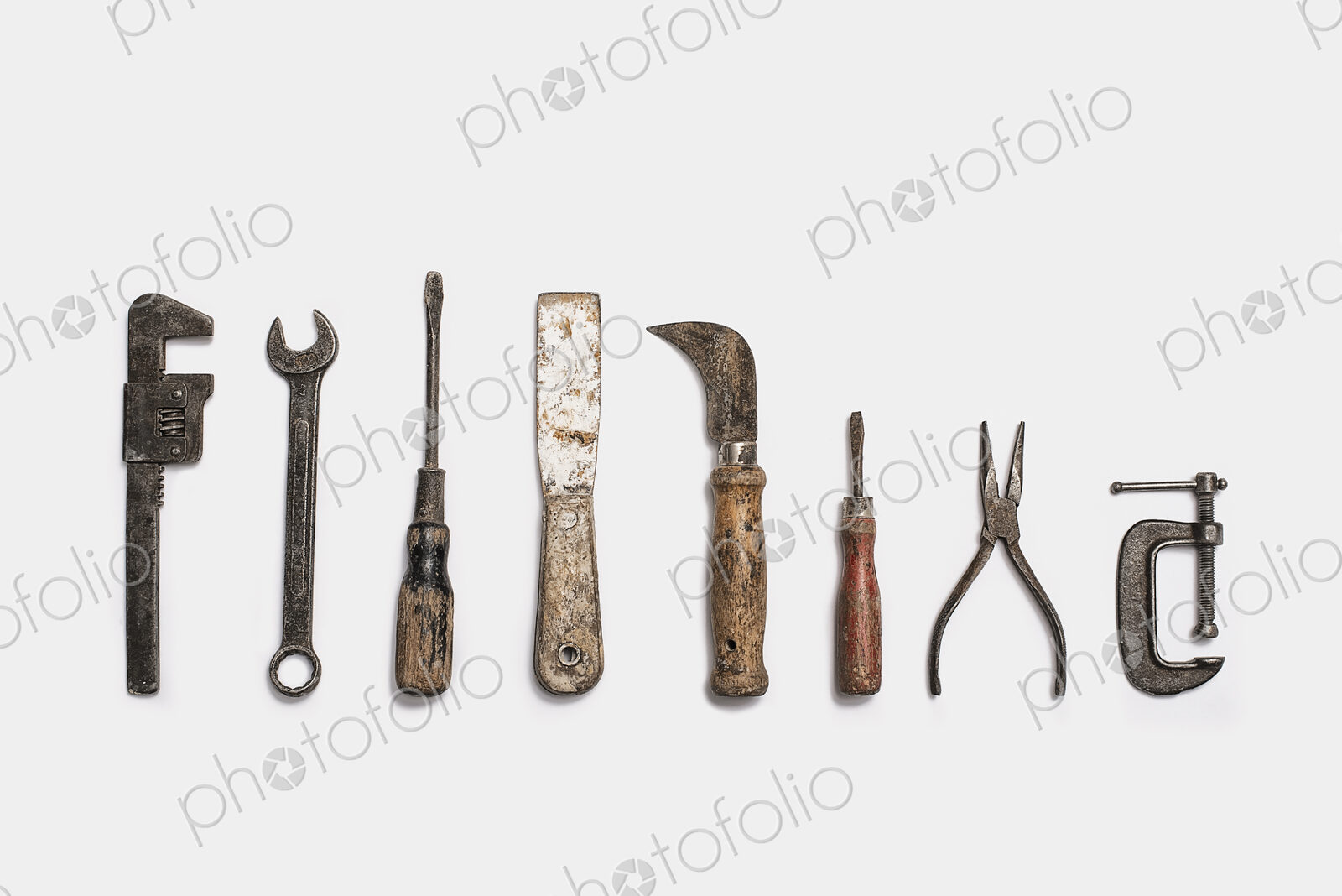 Used tools arranged in a row. Well used, worn handles, shaped wooden smooth texture.…