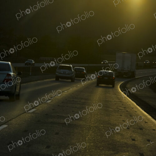 Vehicles on an interstate highway driving towards the sun. Vehicles on an interstate highway driving towards the sun.