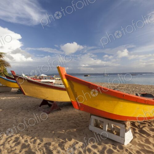 Vibrantly painted wooden fishing boats rest on the golden sand of Crash Boat Beach in… Vibrantly painted wooden fishing boats rest on the golden sand of Crash Boat Beach in…