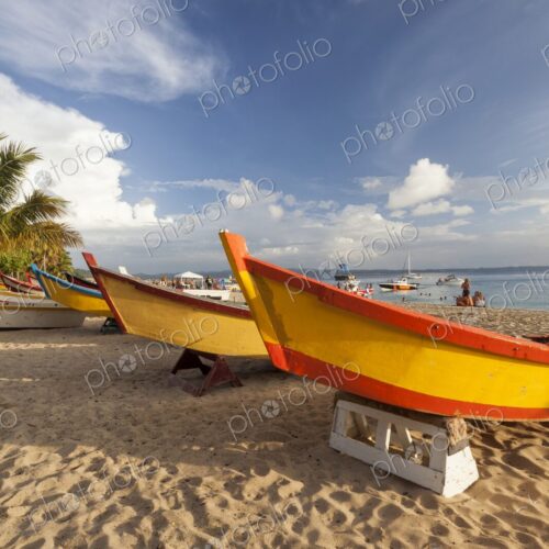 Vibrantly painted wooden fishing boats rest on the golden sand of Crash Boat Beach in… Vibrantly painted wooden fishing boats rest on the golden sand of Crash Boat Beach in…