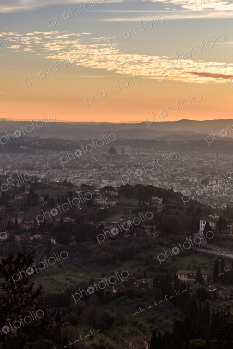 View across Florence city at sunset from above, outlines of city landmarks.