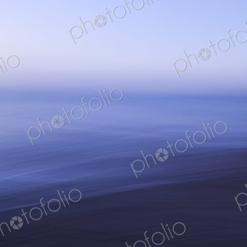 View across a seascape to the horizon, flat calm water surface and blurred motion. View across a seascape to the horizon, flat calm water surface and blurred motion.
