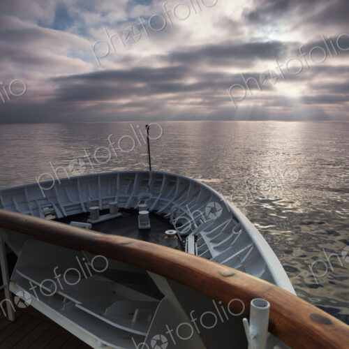 View across the ocean from the bow of a cruise ship at dawn.