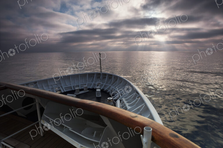 View across the ocean from the bow of a cruise ship at dawn.