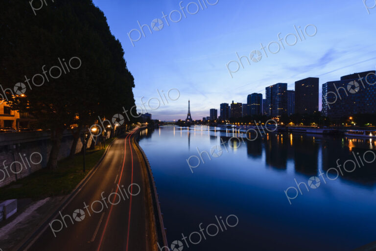 View along the River Seine to the Eiffel tower, the river embankment, and the city at…