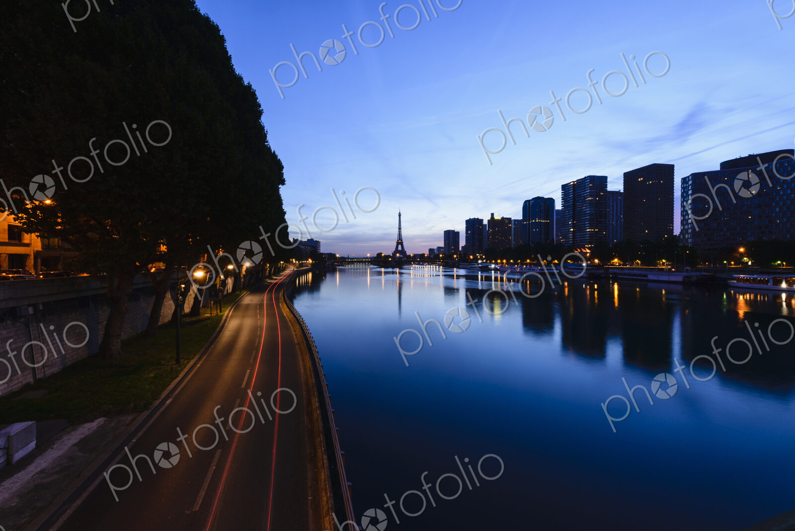 View along the River Seine to the Eiffel tower, the river embankment, and the city at…