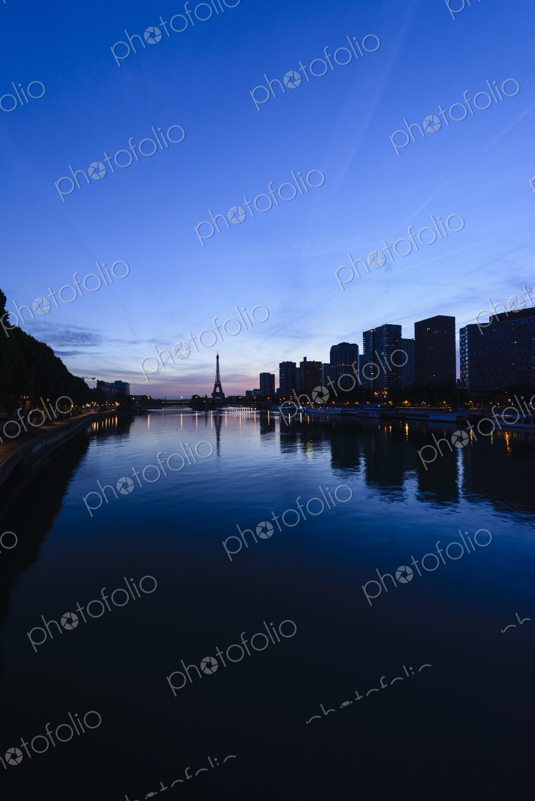 View along the River Seine to the Eiffel tower, the river embankment, and the city at…