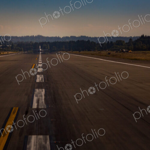 View down an airport runway, an aircraft preparing for take off. View down an airport runway, an aircraft preparing for take off.