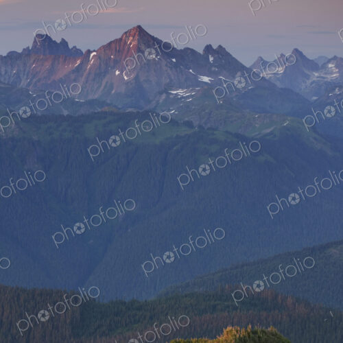 View from above, a small orange tent pitched on a ridge, with views into the valley… View from above, a small orange tent pitched on a ridge, with views into the valley…