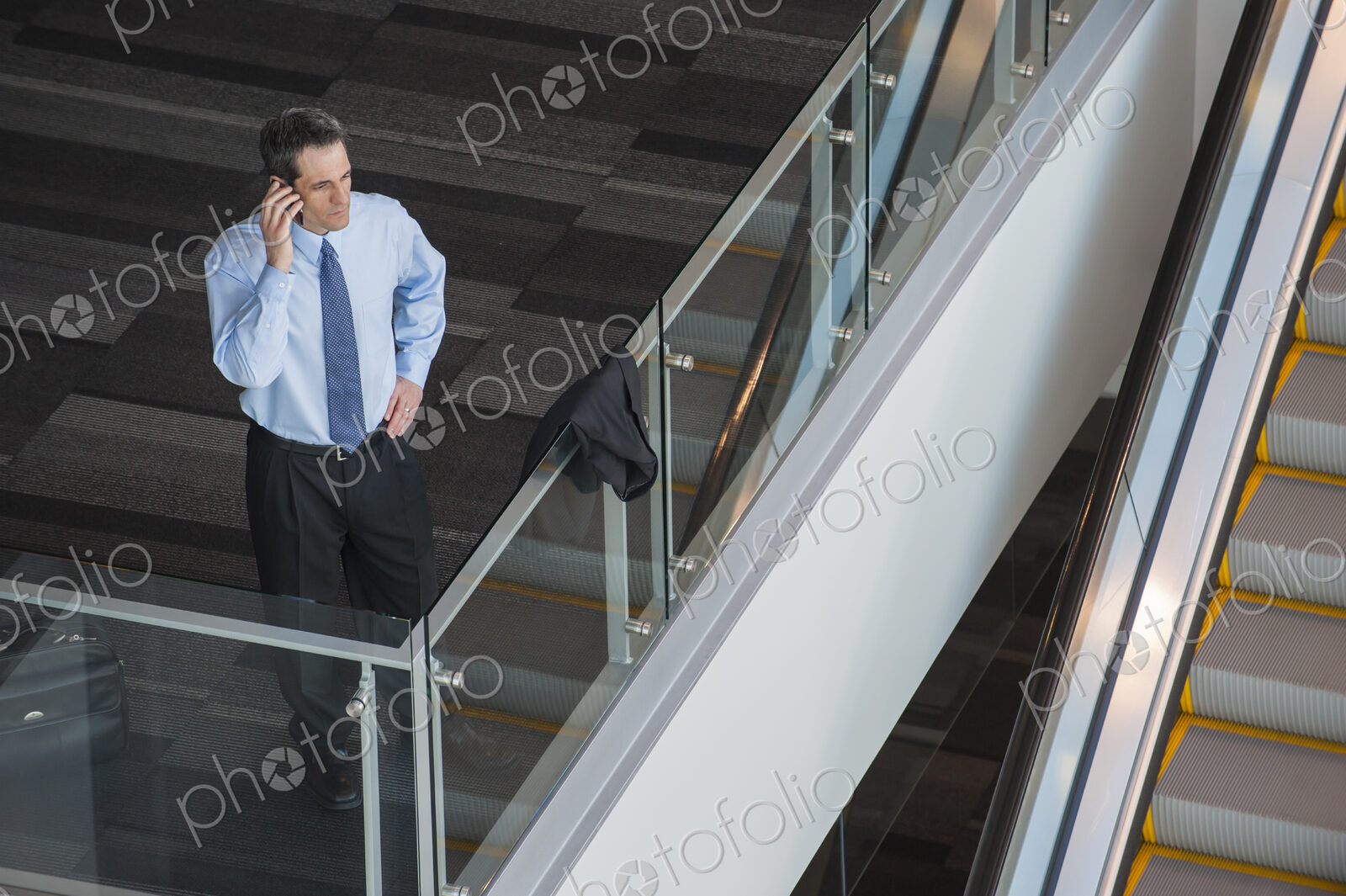 View from above looking down on a businessman using his phone in a conference centre…