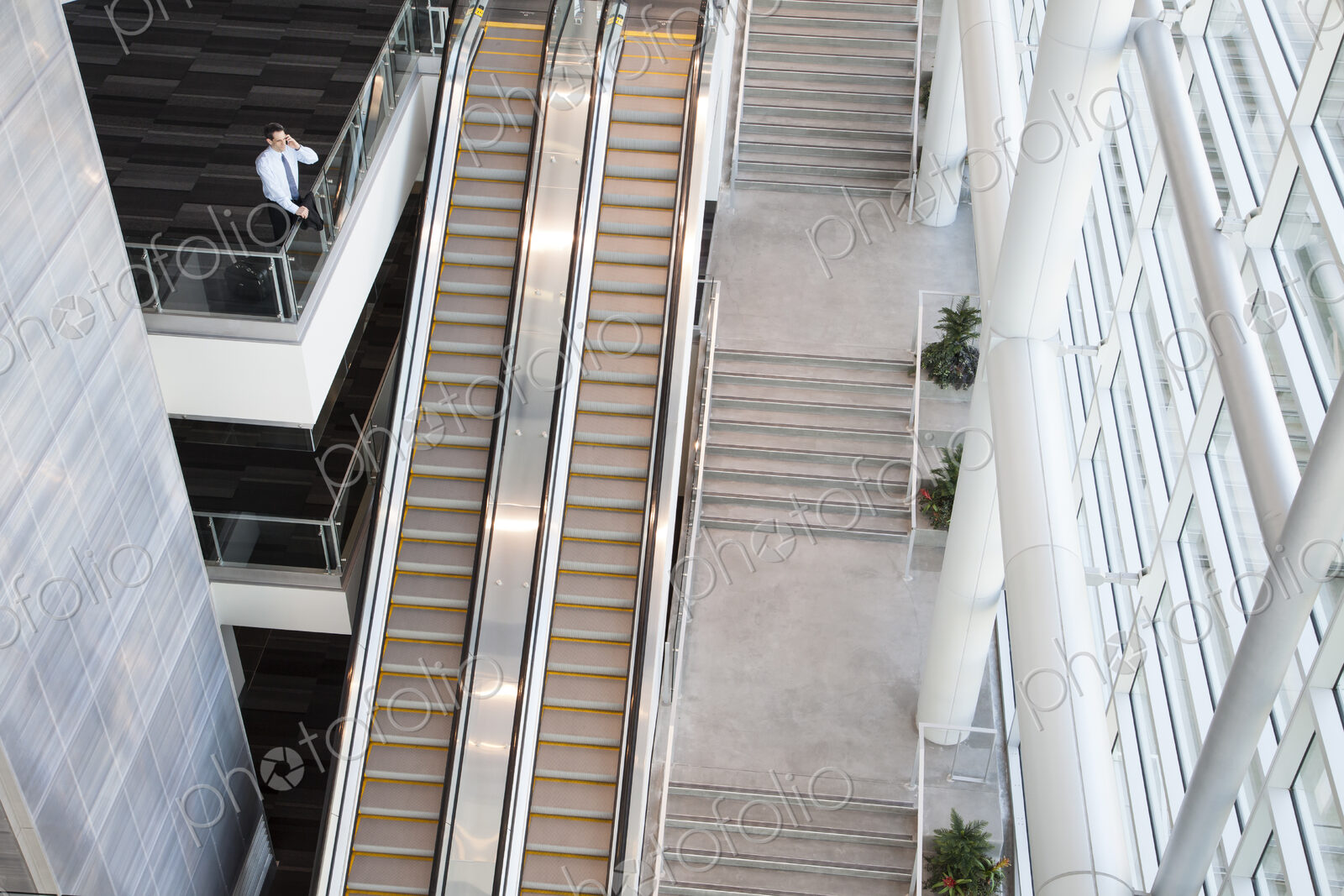 View from above looking down on a businessman using his phone in a conference centre…