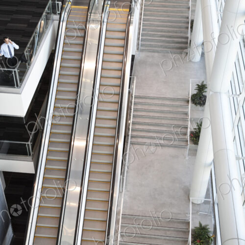 View from above looking down on a businessman using his phone in a conference centre…