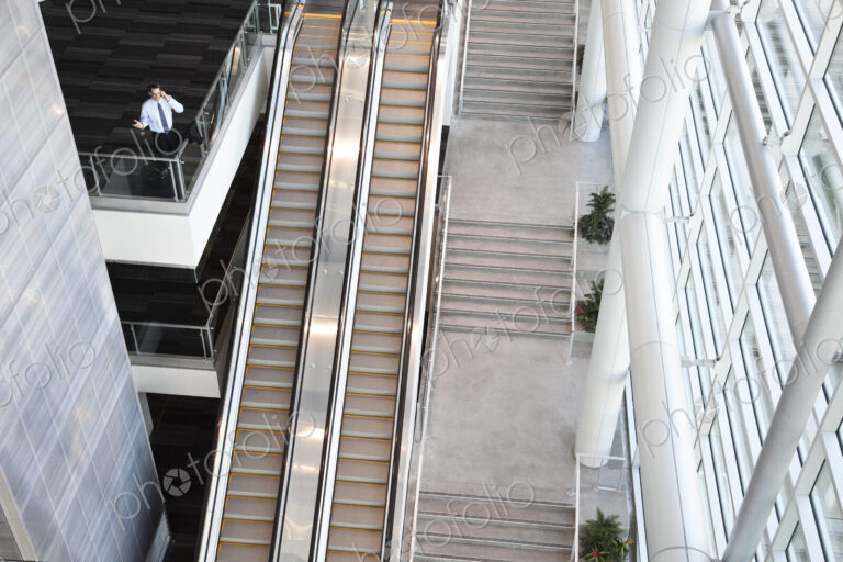 View from above looking down on a businessman using his phone in a conference centre…