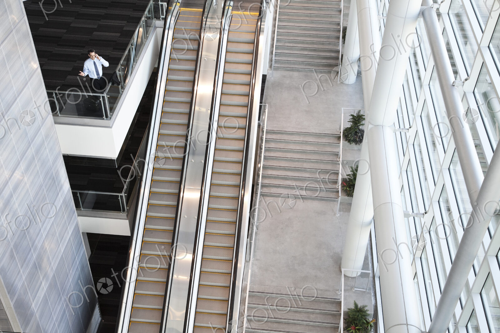 View from above looking down on a businessman using his phone in a conference centre…