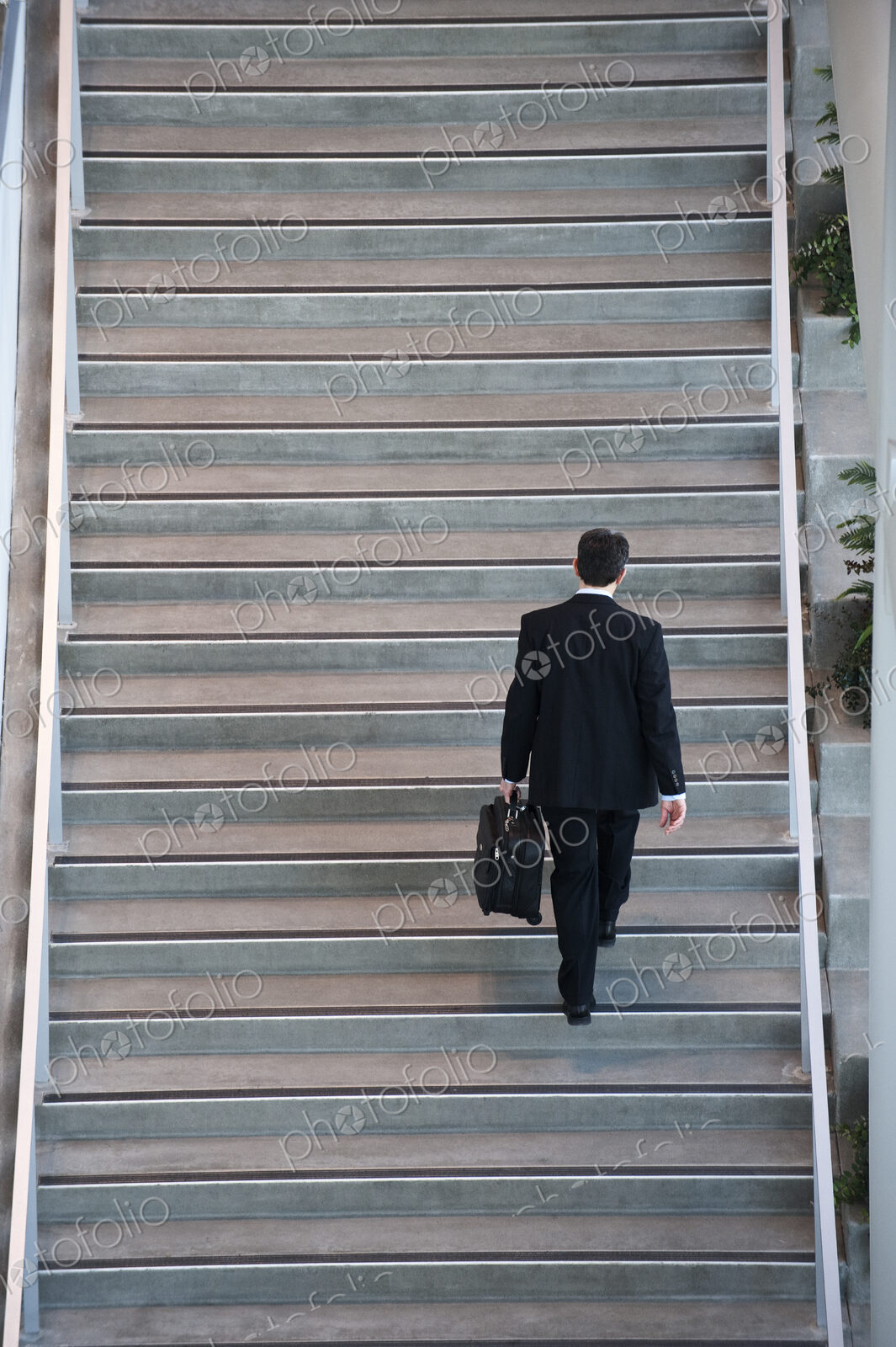 View from above looking down on a businessman walking up stairs in a conference centre…