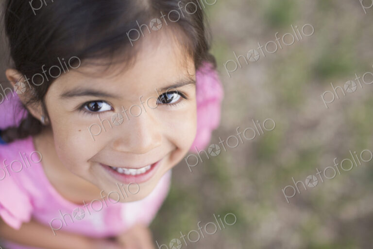 View from above of a child, a girl with dark brown hair and brown eyes.