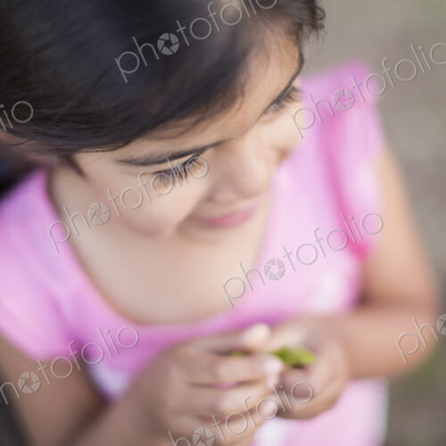 View from above of a child, a girl with dark brown hair and brown eyes.