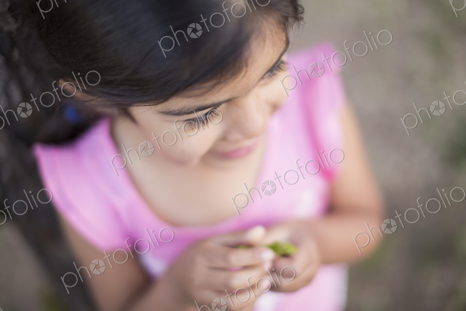 View from above of a child, a girl with dark brown hair and brown eyes.