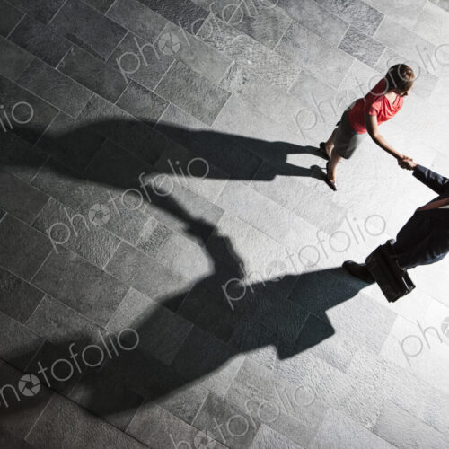 View from above of a handshake and shadows between a businessman and business woman.