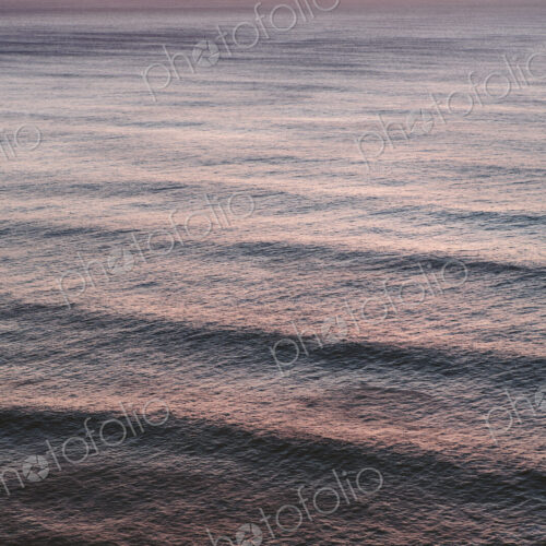 View from above of rolling waves advancing to the shore, a pattern on the water…