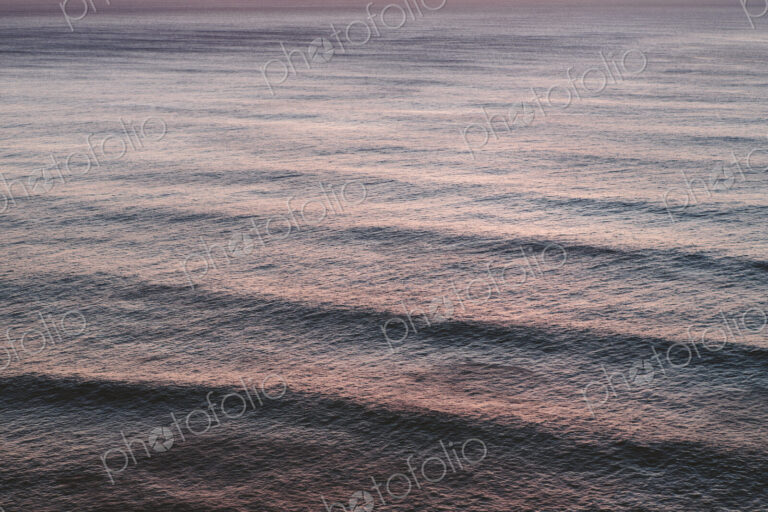 View from above of rolling waves advancing to the shore, a pattern on the water…