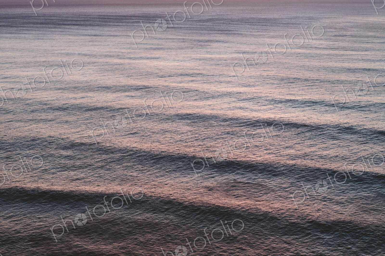 View from above of rolling waves advancing to the shore, a pattern on the water…