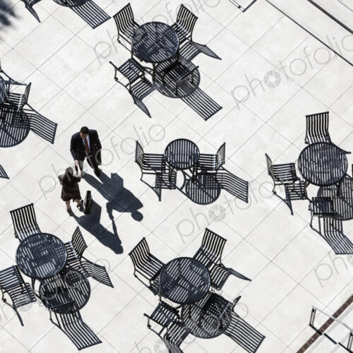 View from above of two business people meeting outside in an open air cafe area. View from above of two business people meeting outside in an open air cafe area.