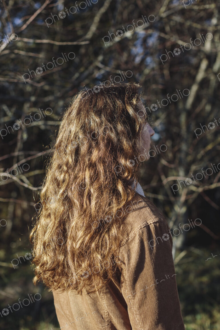 View from behind of teenage girl with long, wavy, brown hair