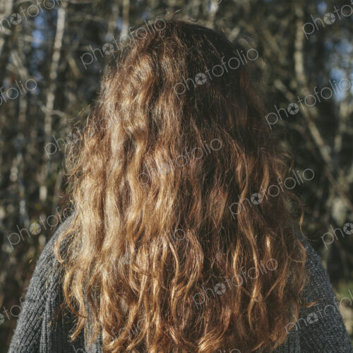 View from behind of teenage girl with long, wavy, brown hair View from behind of teenage girl with long, wavy, brown hair