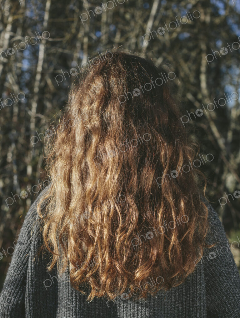 View from behind of teenage girl with long, wavy, brown hair