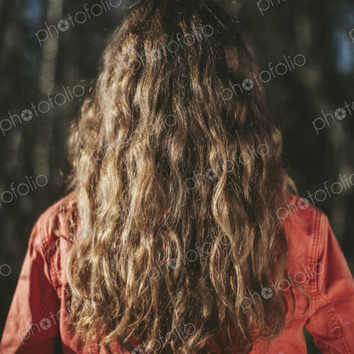 View from behind of teenage girl with long, wavy, brown hair View from behind of teenage girl with long, wavy, brown hair