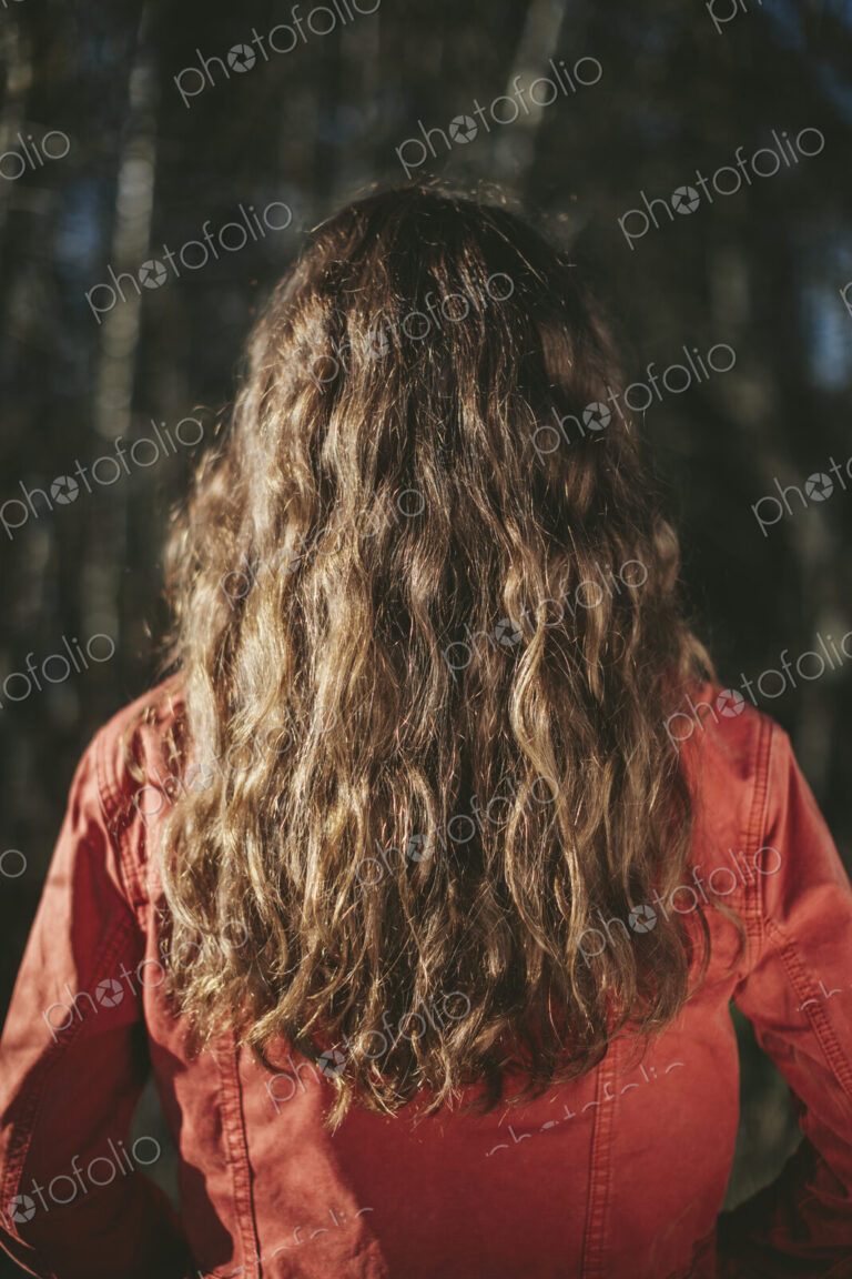 View from behind of teenage girl with long, wavy, brown hair