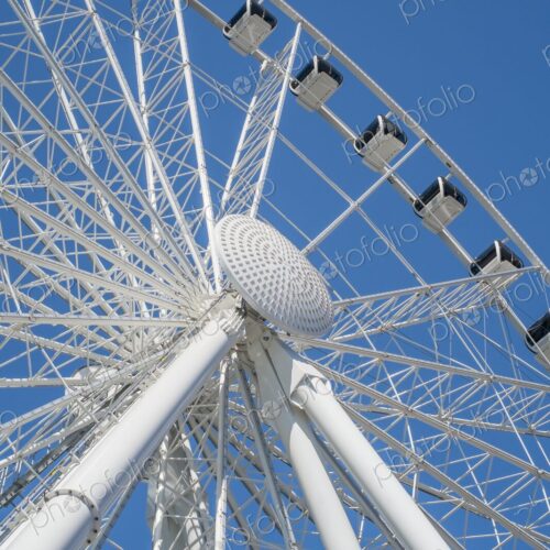 View from below of a Ferris wheel in Seattle, Washington, with white steel beams and…