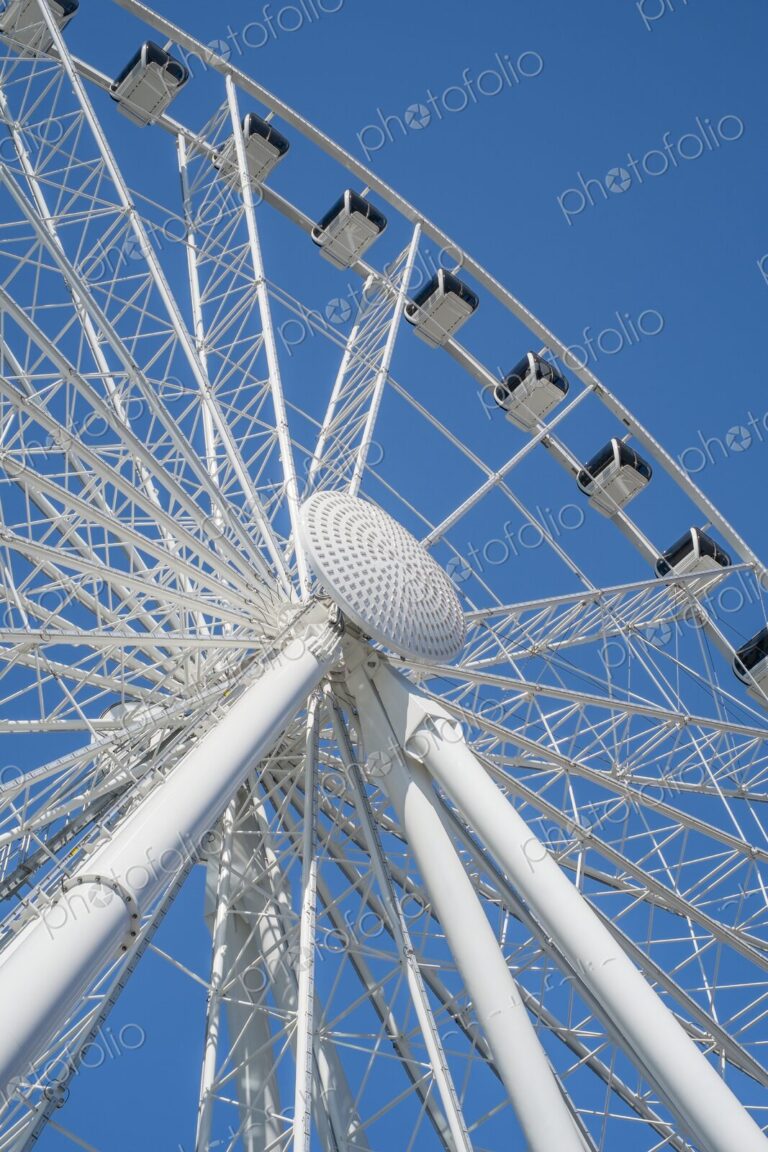 View from below of a Ferris wheel in Seattle, Washington, with white steel beams and…