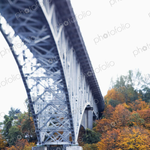 View from below of a metal structure, pillars and arch of bridge