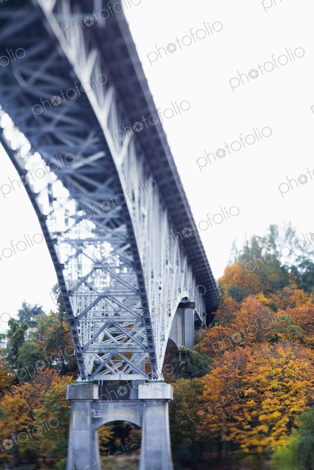 View from below of a metal structure, pillars and arch of bridge