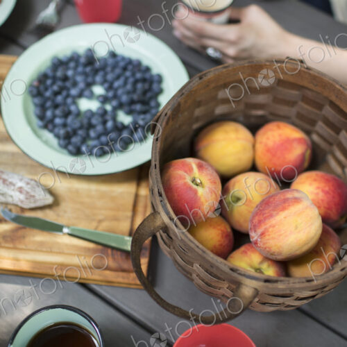 View from overhead of a picnic table with a basket of fresh fruit and salad View from overhead of a picnic table with a basket of fresh fruit and salad