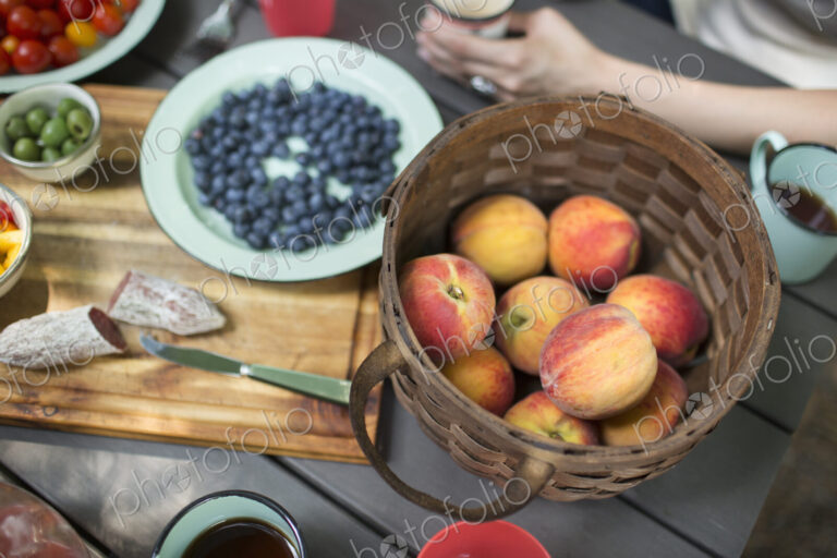 View from overhead of a picnic table with a basket of fresh fruit and salad