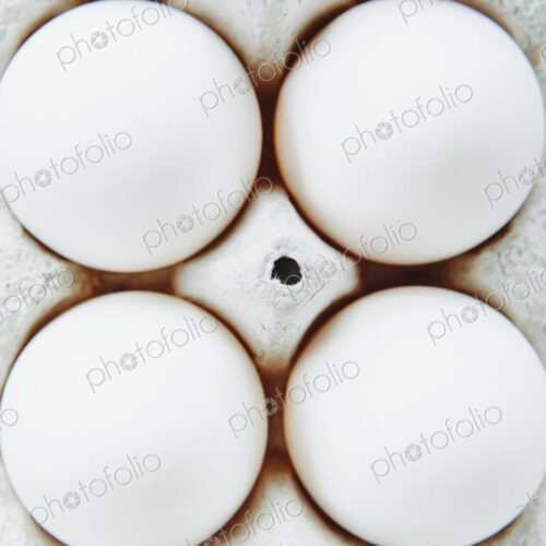 View from overhead of free range, organic eggs in a cardboard egg box carton. View from overhead of free range, organic eggs in a cardboard egg box carton.