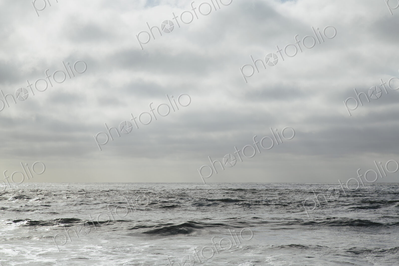 View from the beach over the water, to the horizon, and the seascape at dusk