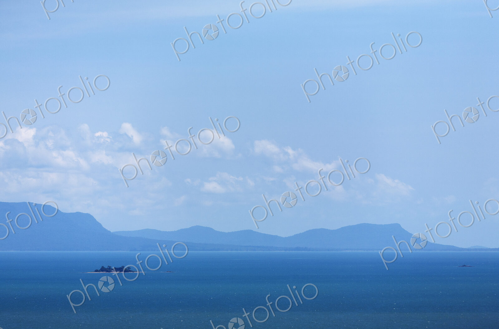 View from the sea of the Cambodian coastline with mountains in the distance.