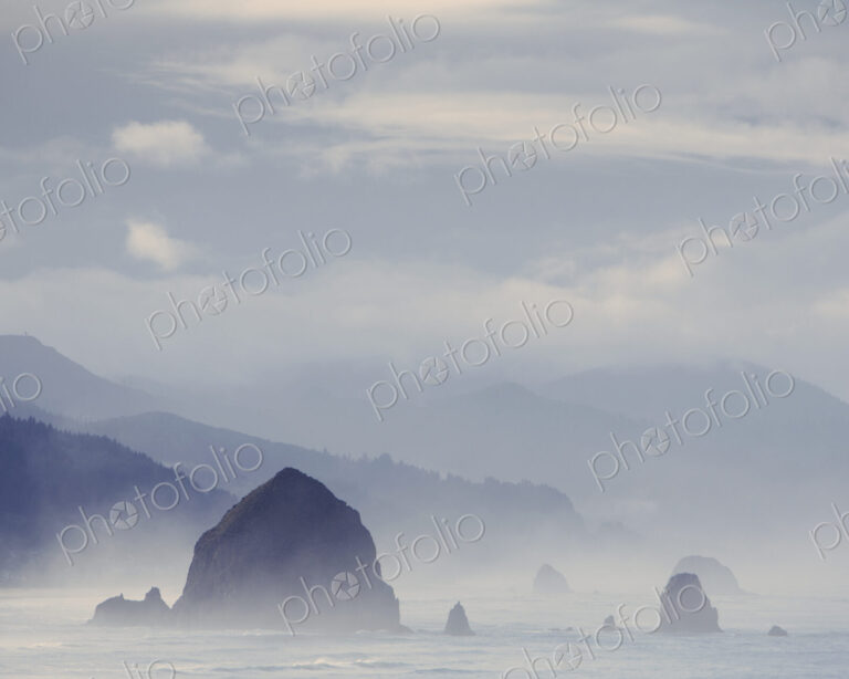 View of Haystack Rock, at Cannon Beach and the coast of the Ecola State Park, Oregon.