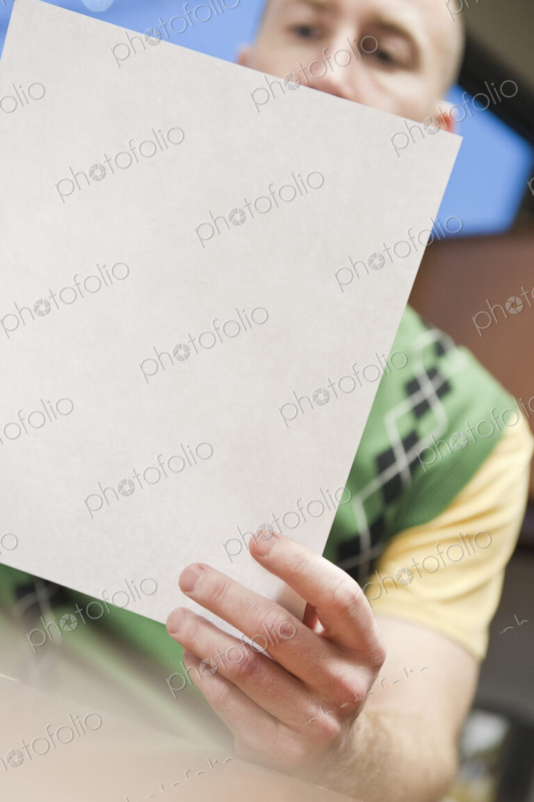 View of a Caucasian man going over paperwork in his office.
